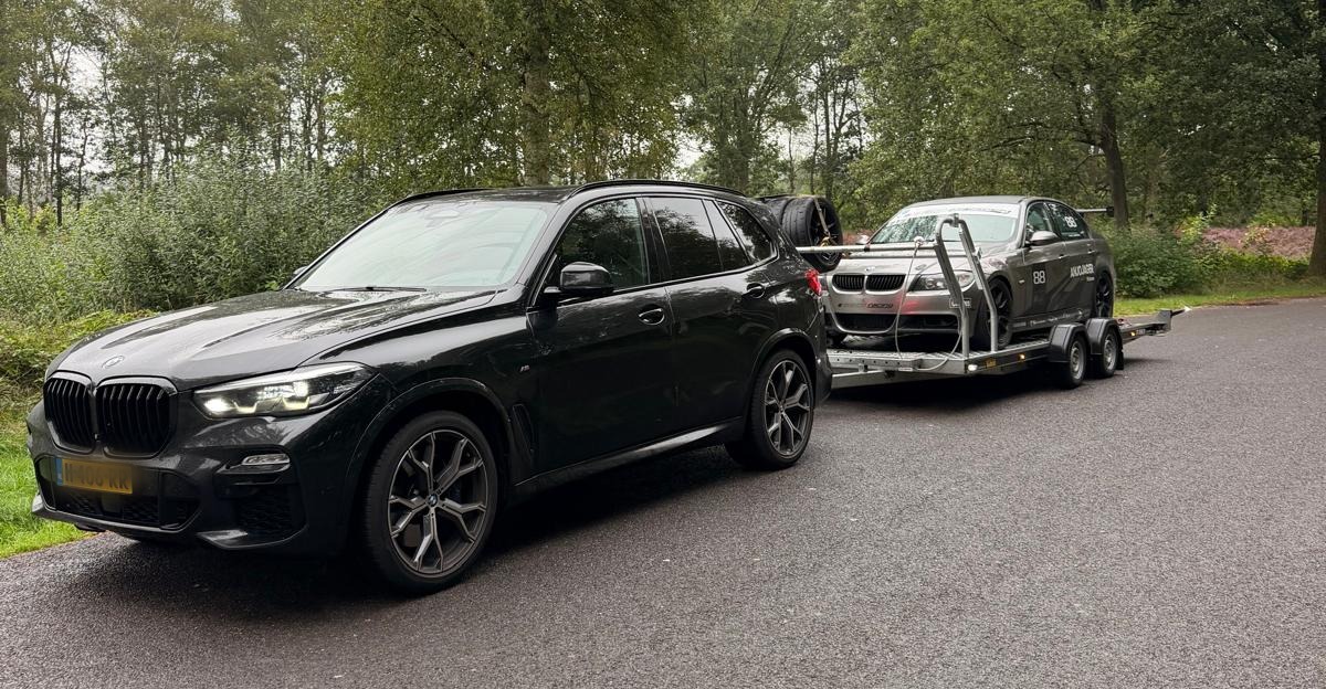 Onze BMW X5 met trailer en raceauto